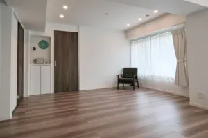 JG Studio features white walls and wood-grain flooring. A simple corner is accented by an antique-style chair."
