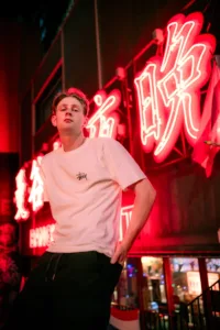 Neon-lit portrait in a Shibuya backstreet at night with glowing signage by JG.