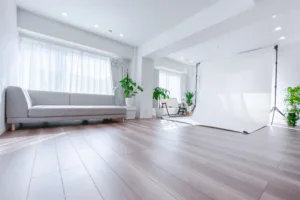 A 2.2m-wide white seamless backdrop set up at JG Studio in Shibuya. A sun-drenched shooting space featuring hardwood floors and a gray sofa.